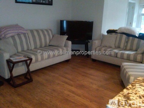 A living room with a striped couch and a wooden coffee table.