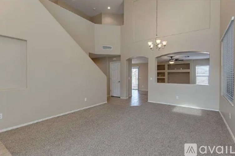 A spacious living room with a staircase leading to the upper level.