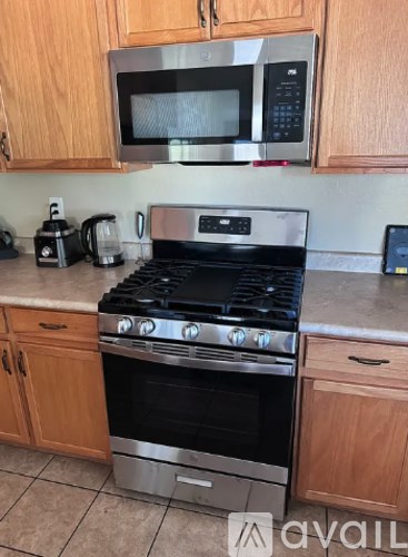 A kitchen with a stove and microwave above it.