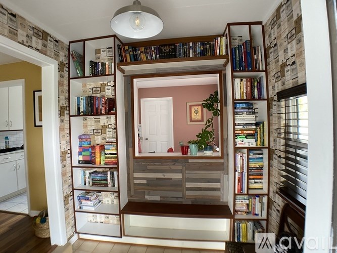 A room with a bookshelf filled with books and a potted plant.