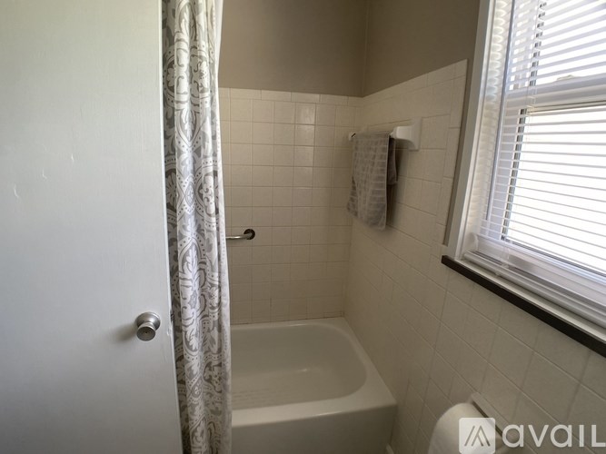 A bathroom with a white tub and a shower curtain.
