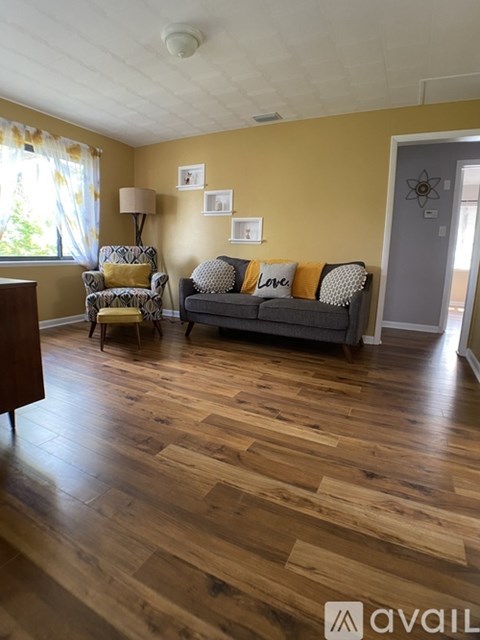 A living room with a grey couch and a yellow chair.