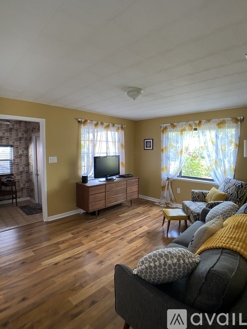 A living room with a grey couch and a wooden floor.
