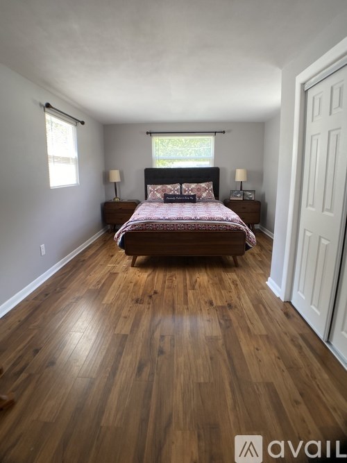 A bedroom with a bed, nightstands, and a window.