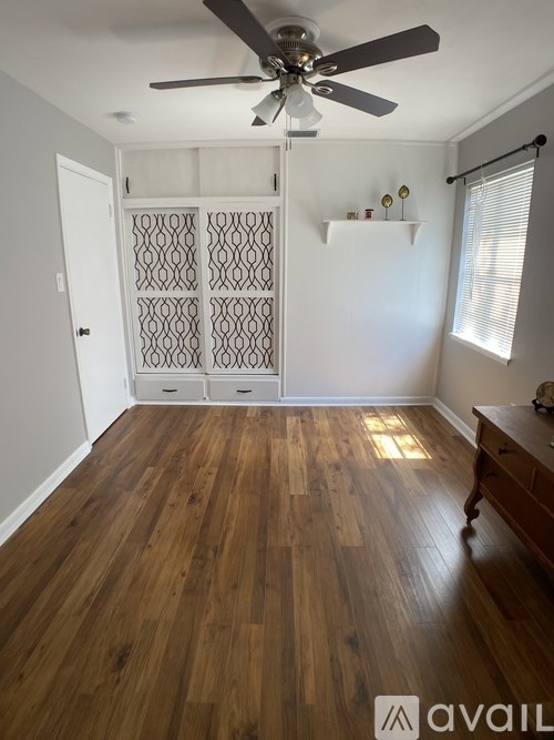 A room with wooden floors and a ceiling fan.