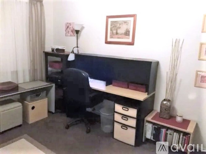 A room with a desk, chair, and a bookshelf.