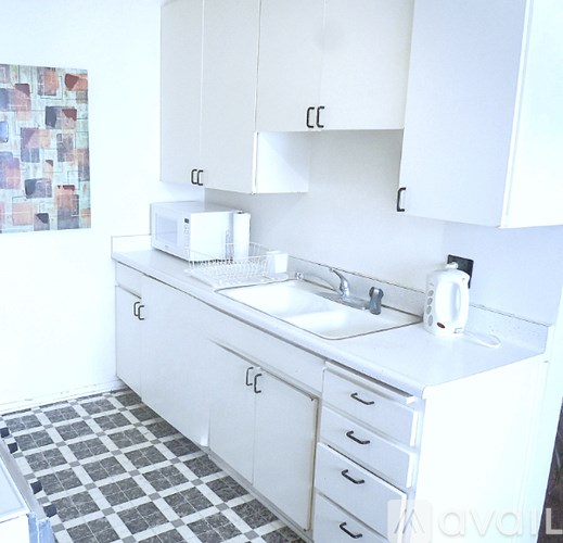 A white kitchen with a sink and a toaster.