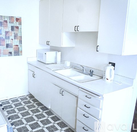 A white kitchen with a sink and a toaster.
