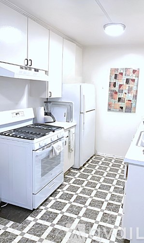 A white kitchen with a black and white checkered floor.