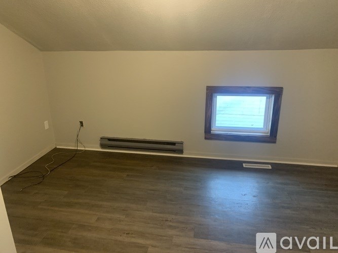 A room with a window and a radiator on the wall.