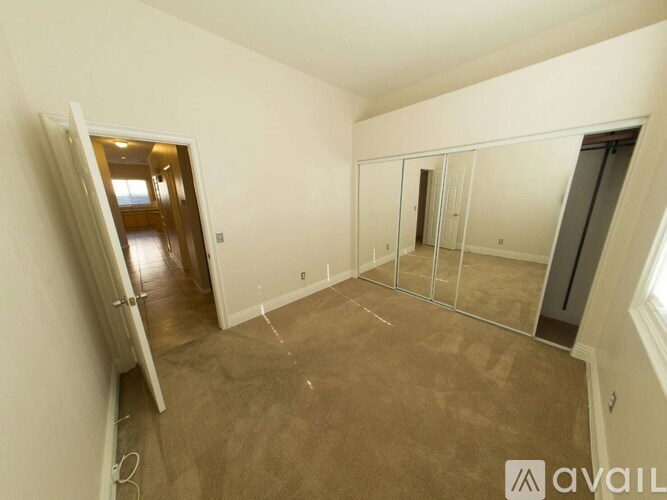 A room with a brown carpet and a white door.