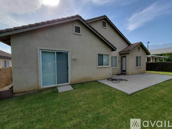 A house with a beige exterior and a blue door is for sale.
