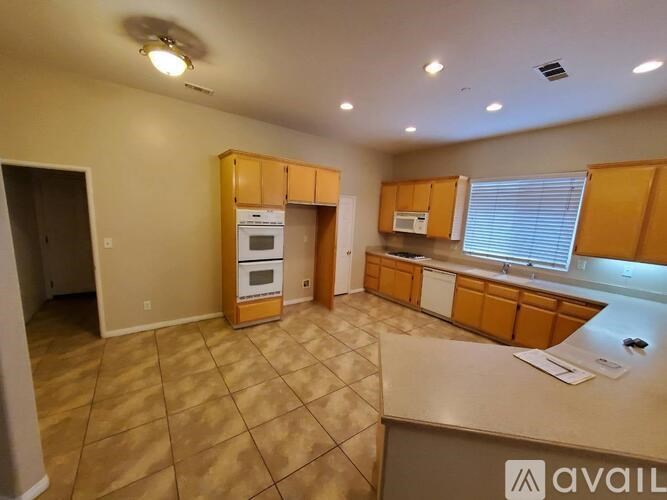 A kitchen with wooden cabinets and a tile floor.
