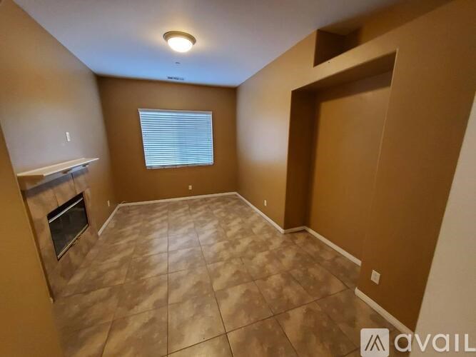 A room with a tiled floor and a window with blinds.