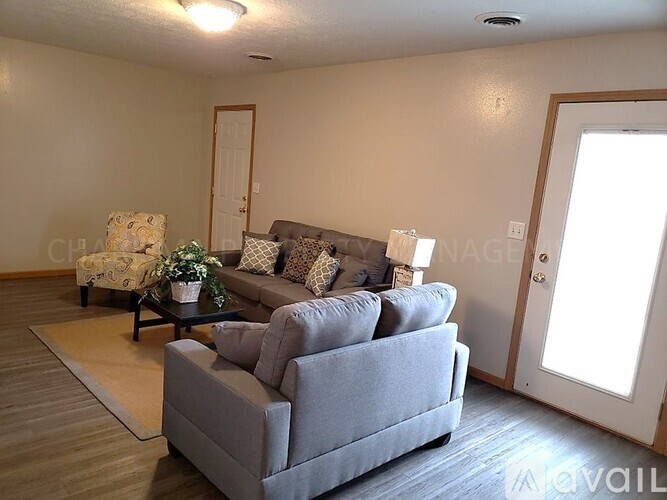 A grey couch with a potted plant on a wooden table in a room.