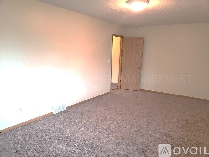 A carpeted room with a door and a sign that says "Management".