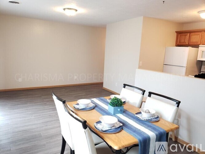 A dining room with a wooden table set for two.