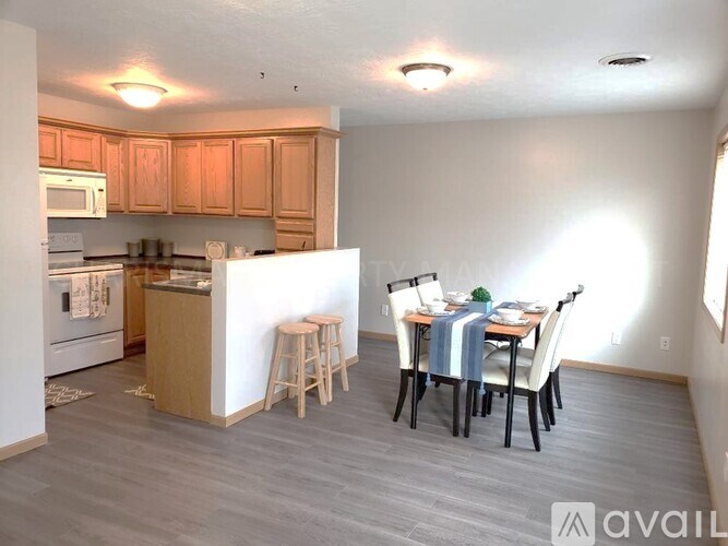 A kitchen with a dining table and chairs.