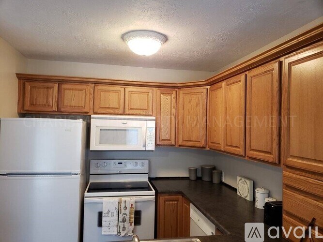 A kitchen with wooden cabinets and a white refrigerator.