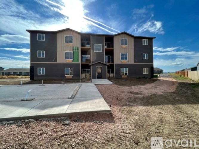A large, multi-story residential building with a parking lot in front.