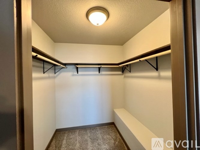 A small, empty room with a carpeted floor and a light on the ceiling.