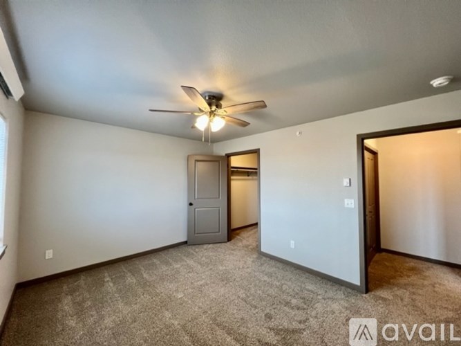 A room with a ceiling fan and carpeted floor.