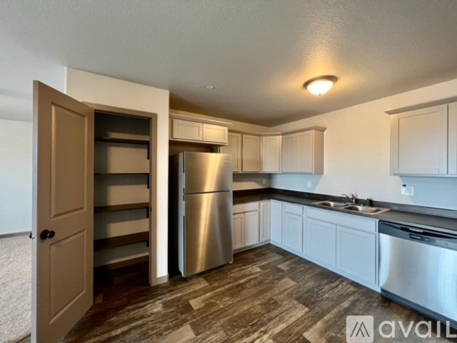 A kitchen with a refrigerator, stove, and cabinets.