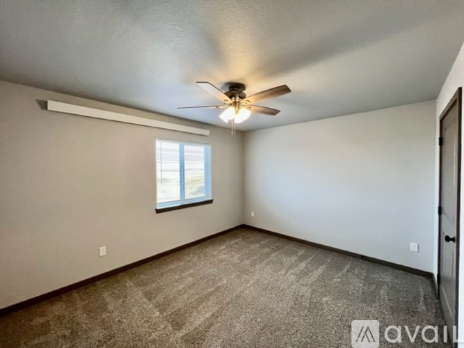 A room with a ceiling fan and a window.