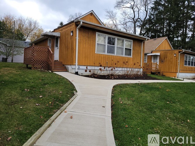A wooden house with a brown door and windows.