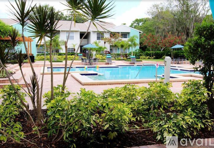 A pool surrounded by green plants and trees.