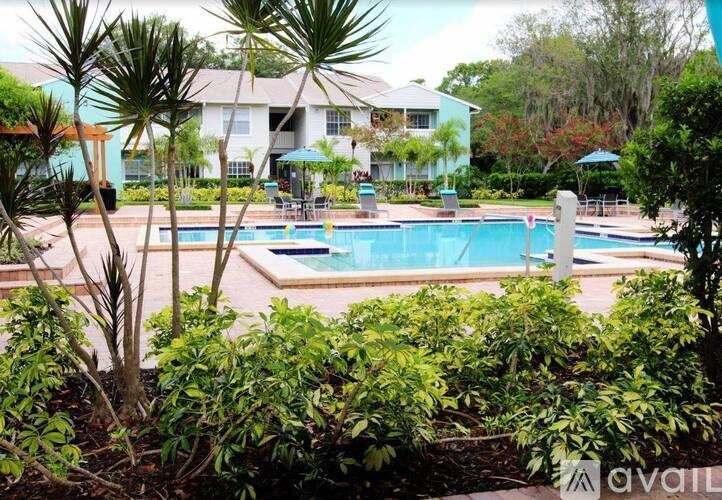 A pool surrounded by green plants and trees.