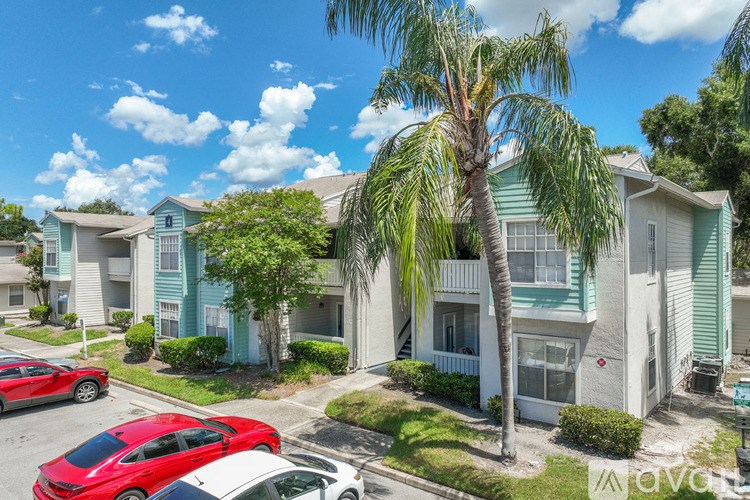 A red car is parked in front of a blue and white building.
