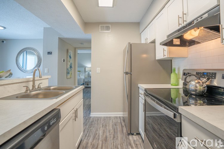 A kitchen with a stainless steel refrigerator and a stove top oven.