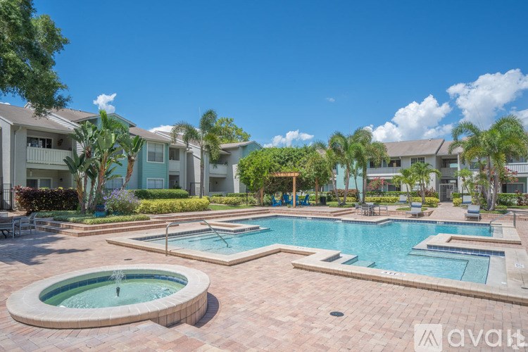 A large outdoor swimming pool with a hot tub in the middle of a residential area.