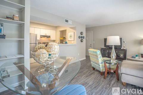 A modern living room with a glass table and a sofa.