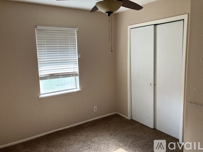 A room with a window and a ceiling fan.