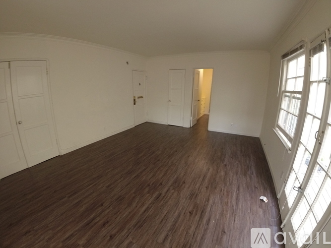 A room with wooden flooring and white walls.