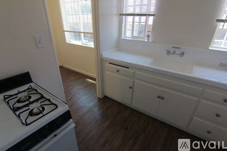 A kitchen with a stove top oven and a sink.