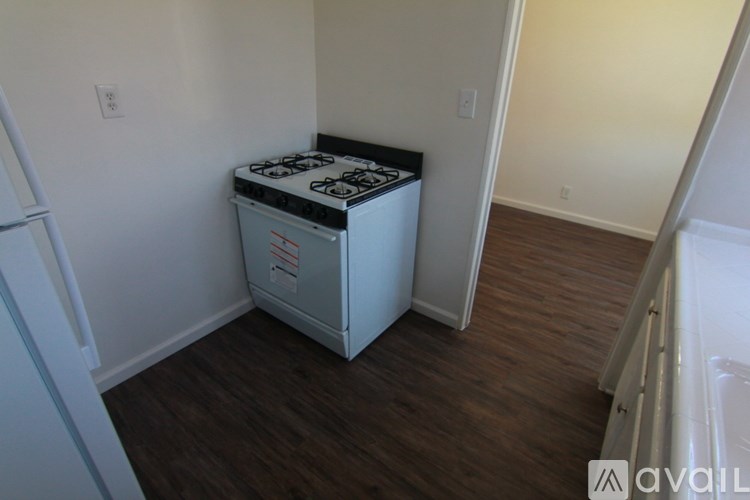 A white gas stove in a room with wood flooring.
