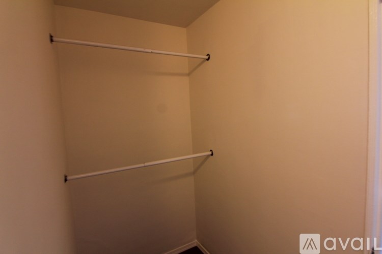 A small, empty room with a white wall and a white door.