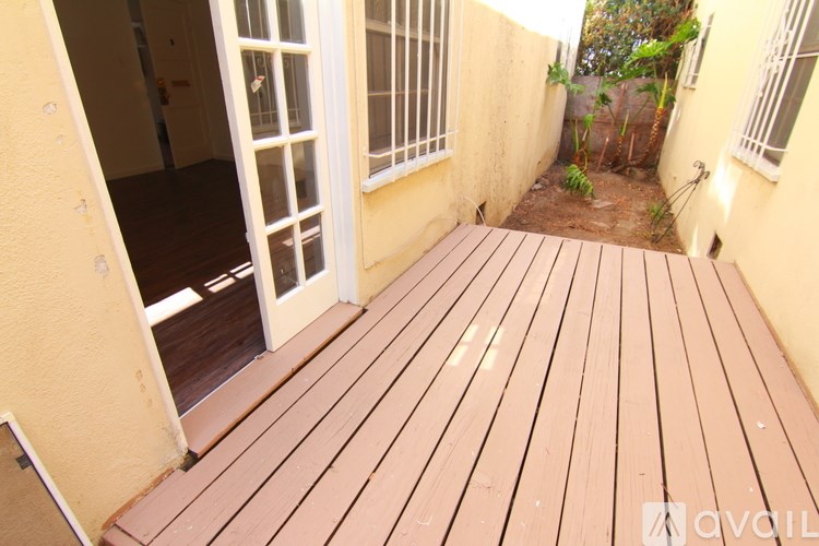 A wooden deck with a door and windows.
