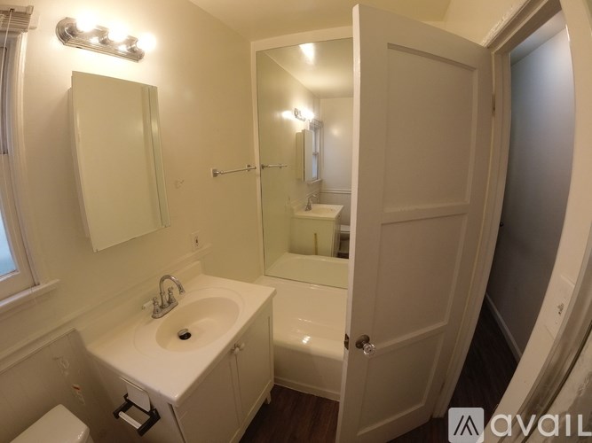 A small white bathroom with a sink, mirror, and toilet.