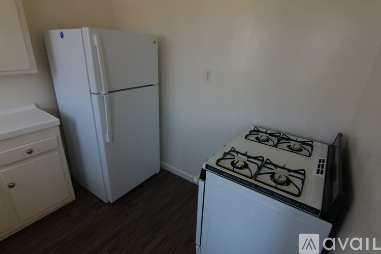 A white fridge and stove in a small kitchen.