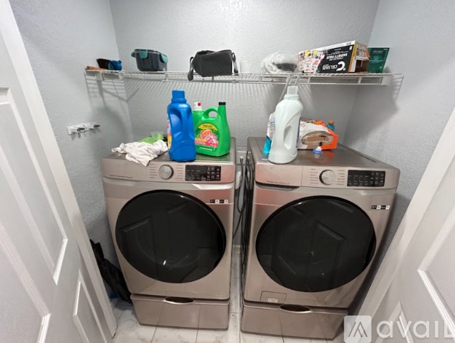 Two front loading washing machines in a small laundry room.