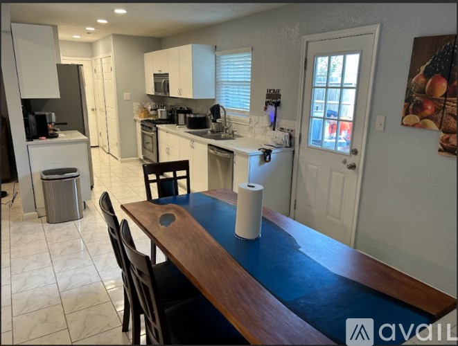 A kitchen with a dining table and chairs.