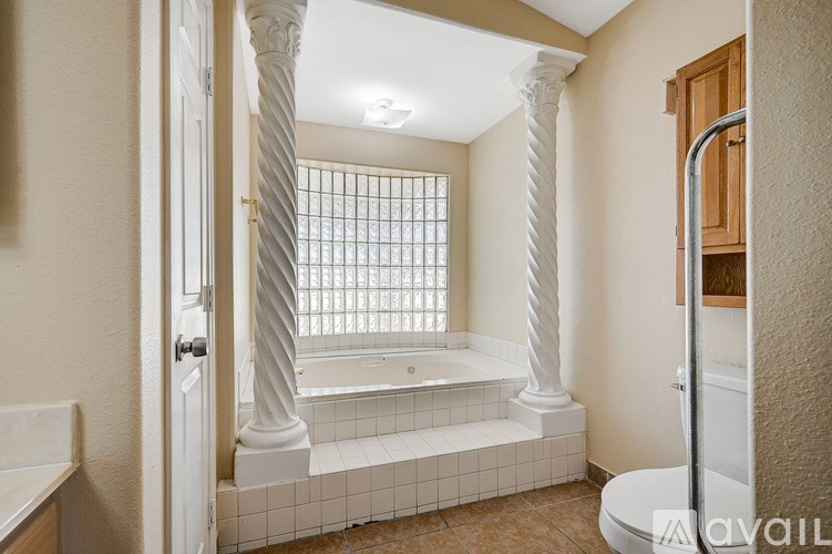 A bathroom with a white bathtub and a window.