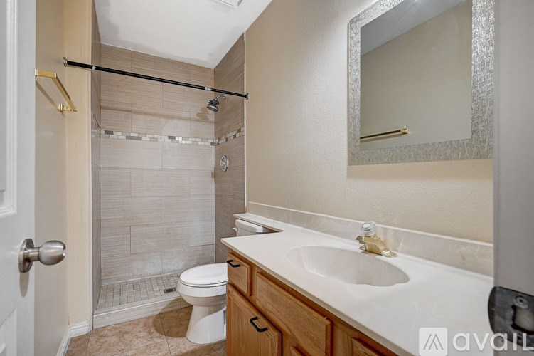 A bathroom with a toilet, sink, and shower.
