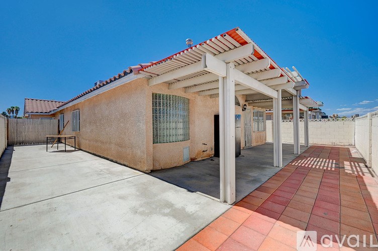 A house with a red and white striped roof and a patio with a table and chairs.