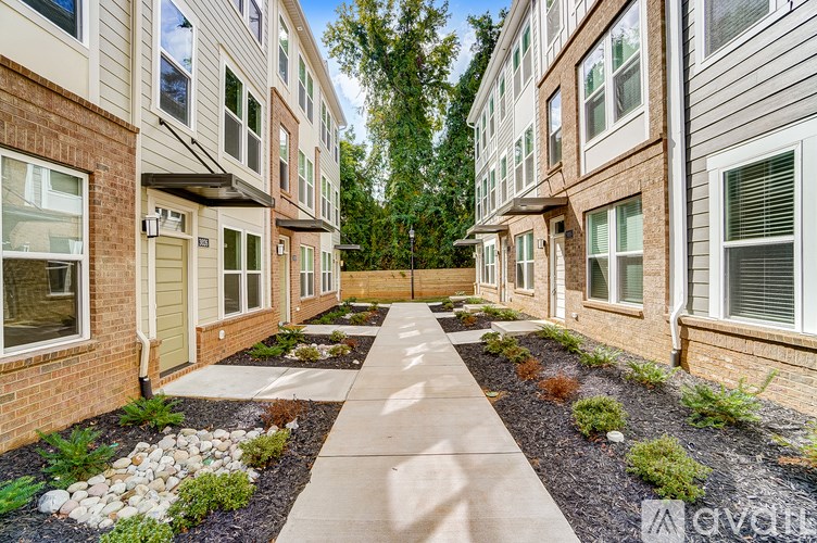 A row of townhouses with a sidewalk in between.
