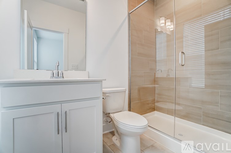 A white toilet sits in a bathroom with a glass shower stall.